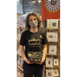 Noah wears a black tshirt with gold text gather remotely and holds a black zipper notions bag with gold printing