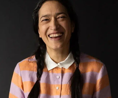 Person wearing a striped shirt with a dark background