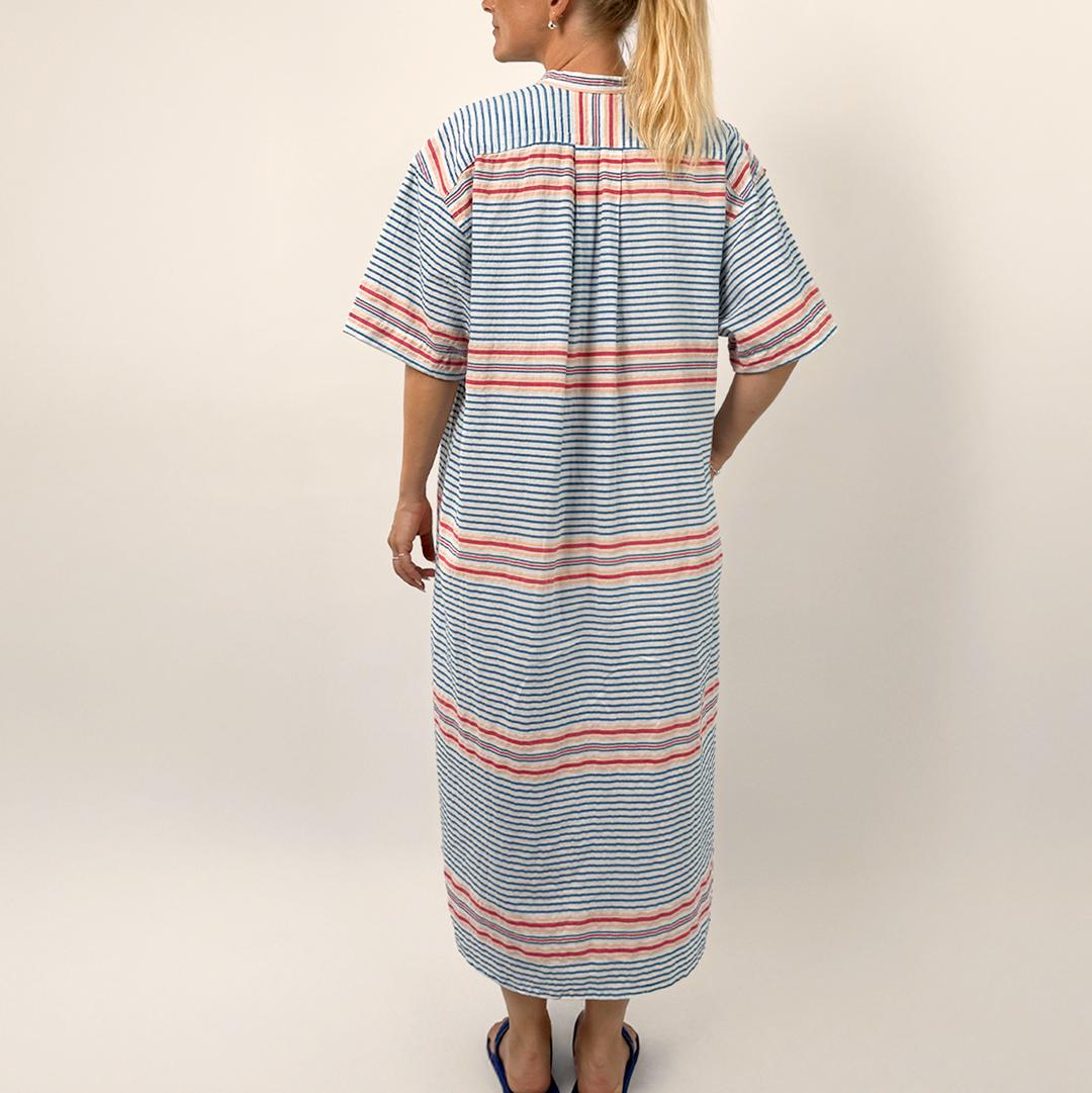 Woman wearing a striped dress with a plain background