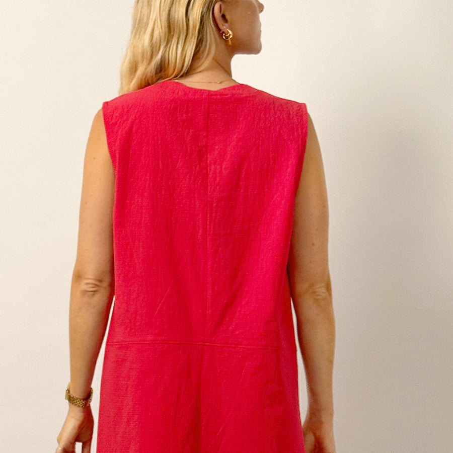 Red dress worn by a person on a plain background