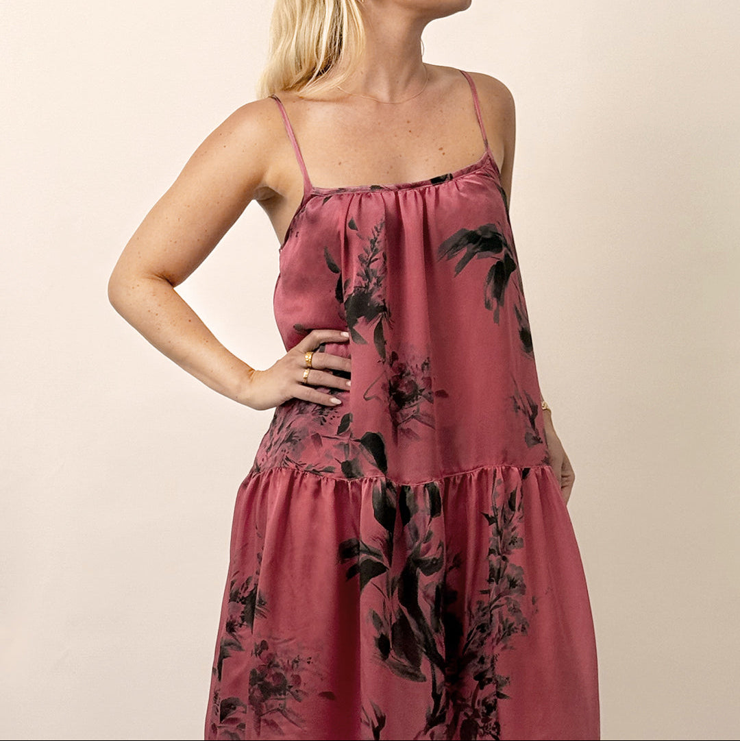 Woman wearing a pink floral dress against a beige background