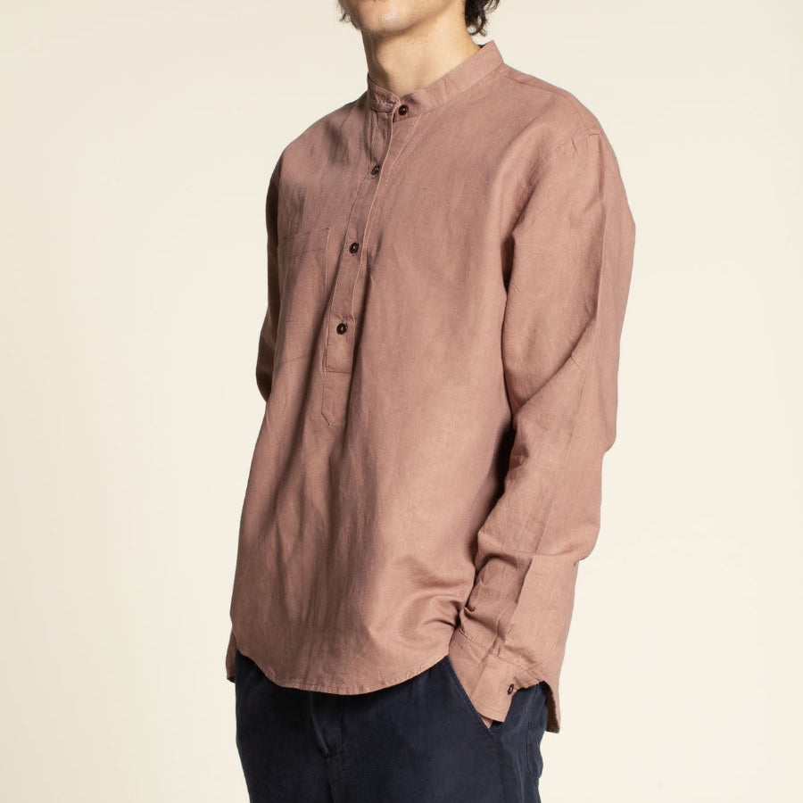 Man wearing a brown shirt against a beige background